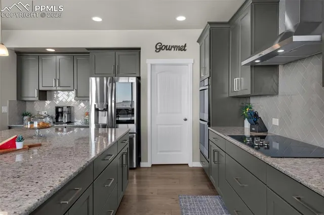 a kitchen with stainless steel appliances granite countertop a sink refrigerator and cabinets