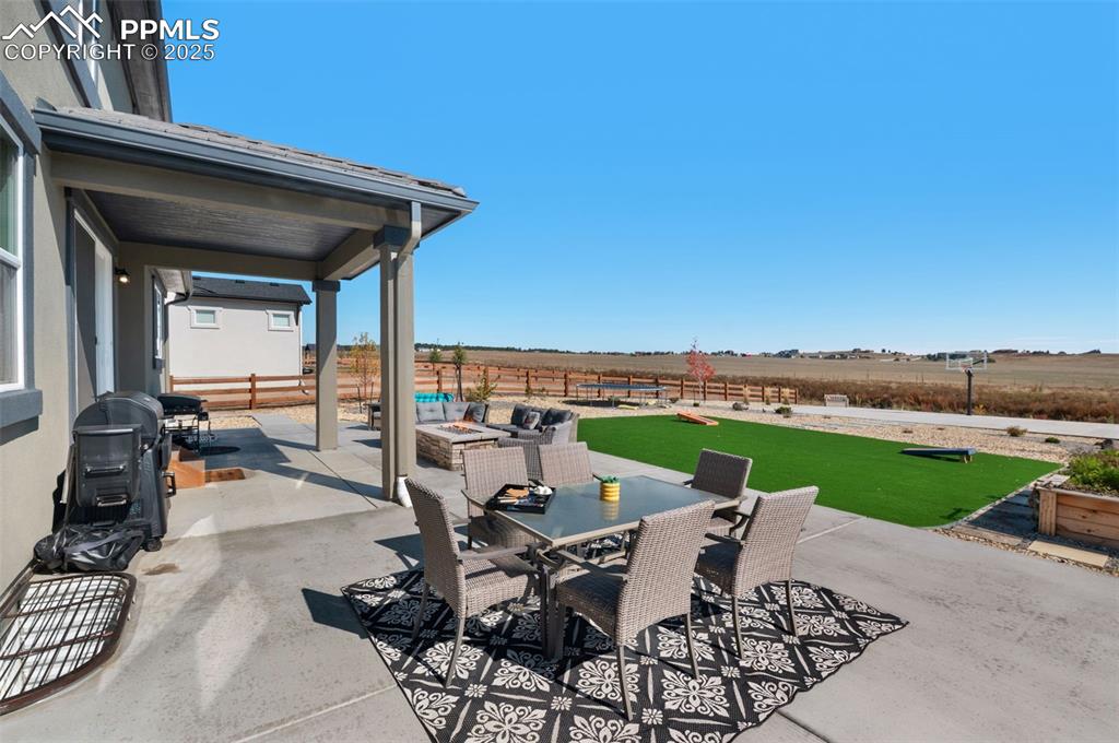 9755 Owl Perch Loop Colorado Springs, CO 80908 - Photo 45 of 50 a view of a patio with lawn chairs floor to ceiling window and an outdoor seating
