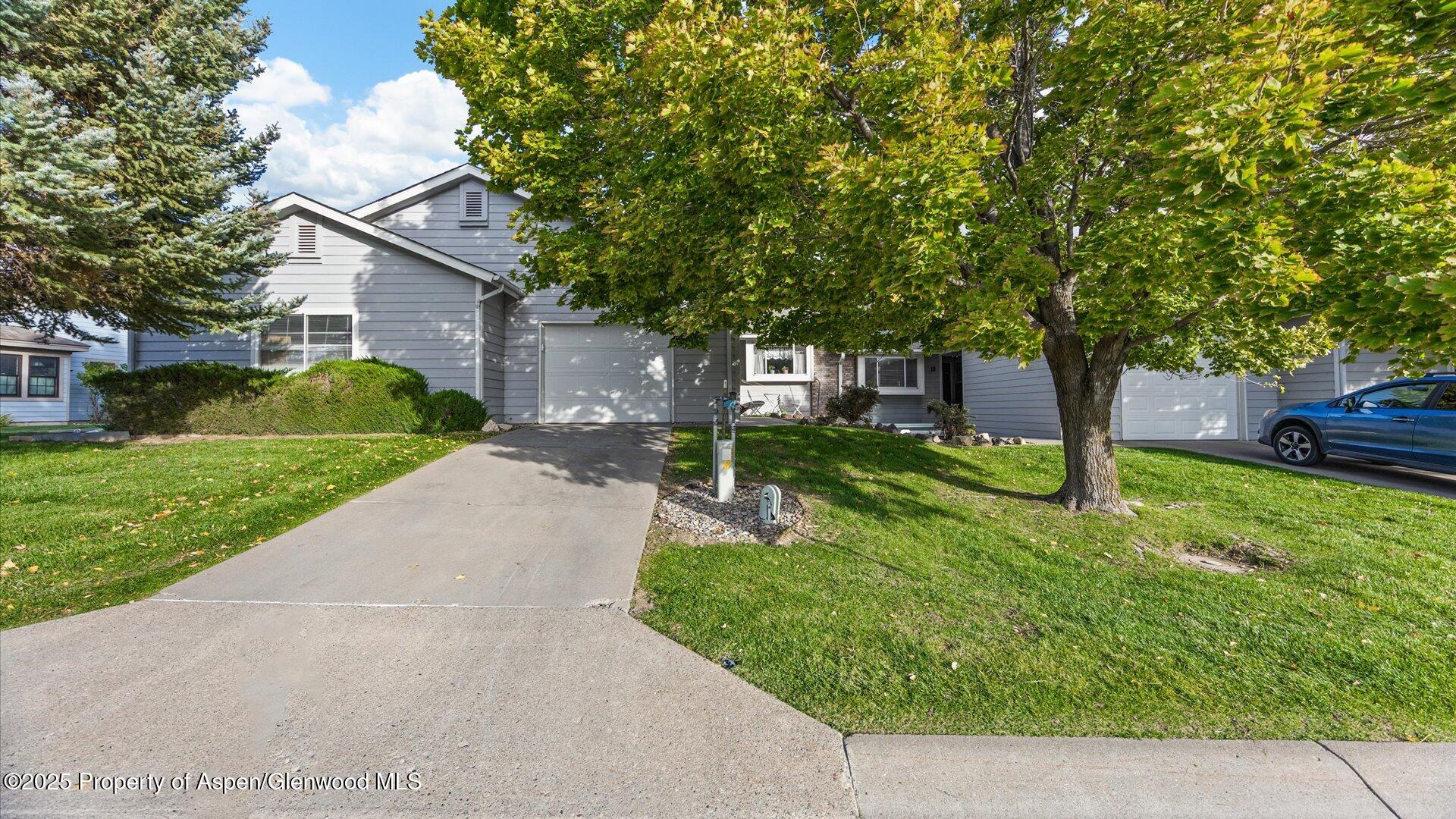 9 West Ridge Court, Unit 1113 Parachute, CO 81635 - Photo 1 of 27 a view of a house with a small yard and a large tree