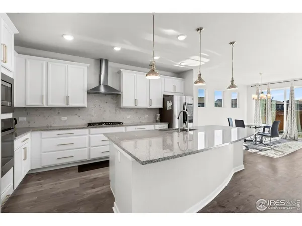 a large kitchen with kitchen island a large counter top space a sink stainless steel appliances and cabinets