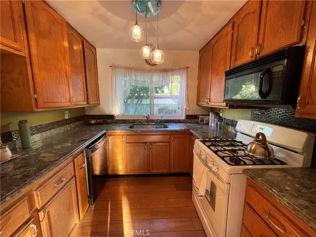a kitchen with stainless steel appliances granite countertop a stove a sink and a microwave