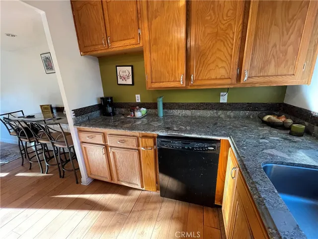 a kitchen with granite countertop a stove a sink and a microwave