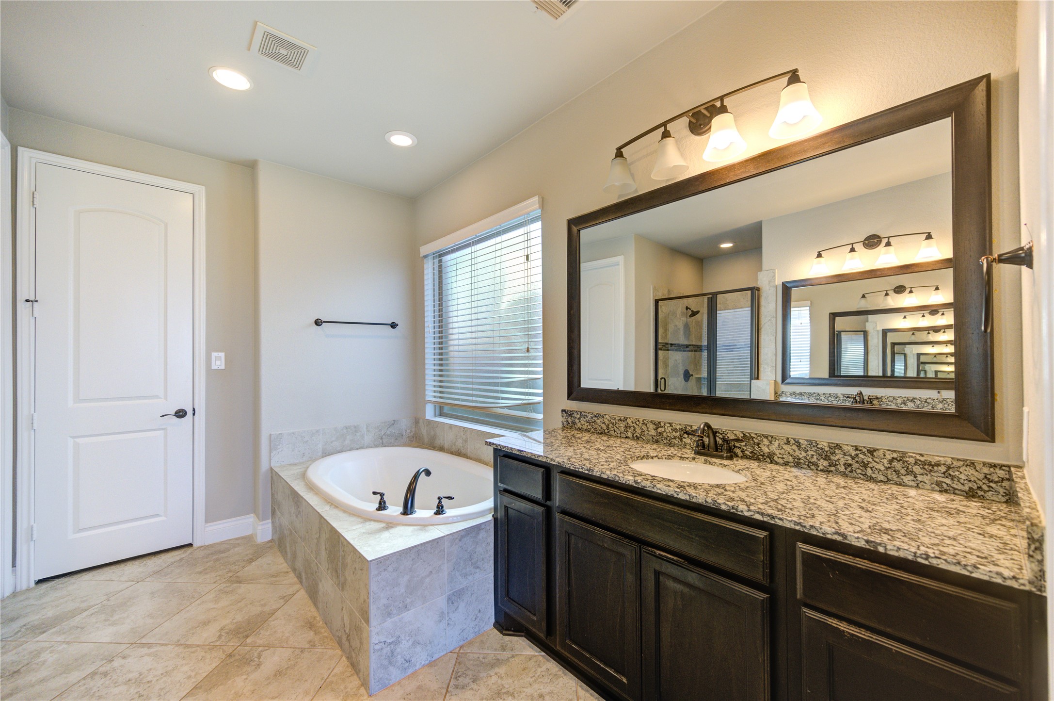 4207 Abigail Way Sugar Land, TX 77479 - Photo 24 of 48 a bathroom with a tub a double vanity sink and a large mirror