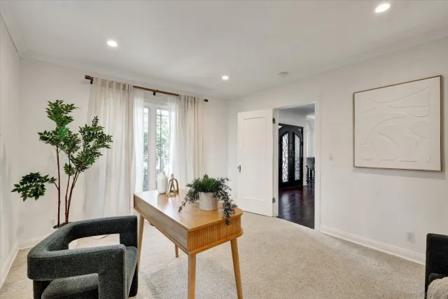 a view of a hallway to a livingroom with furniture and a potted plant