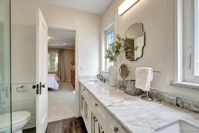 a bathroom with a granite countertop sink a toilet and a shower