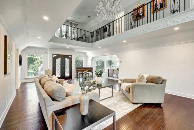 a living room with furniture and hard wood floor