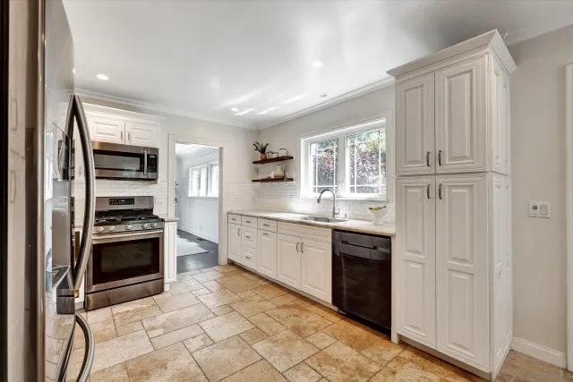 a large kitchen with cabinets and stainless steel appliances
