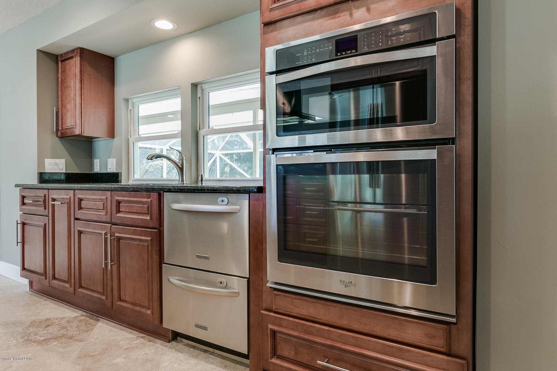 515 Rio Lane Melbourne, FL 32903 - Photo 7 of 15 a kitchen with granite countertop white cabinets and stainless steel appliances