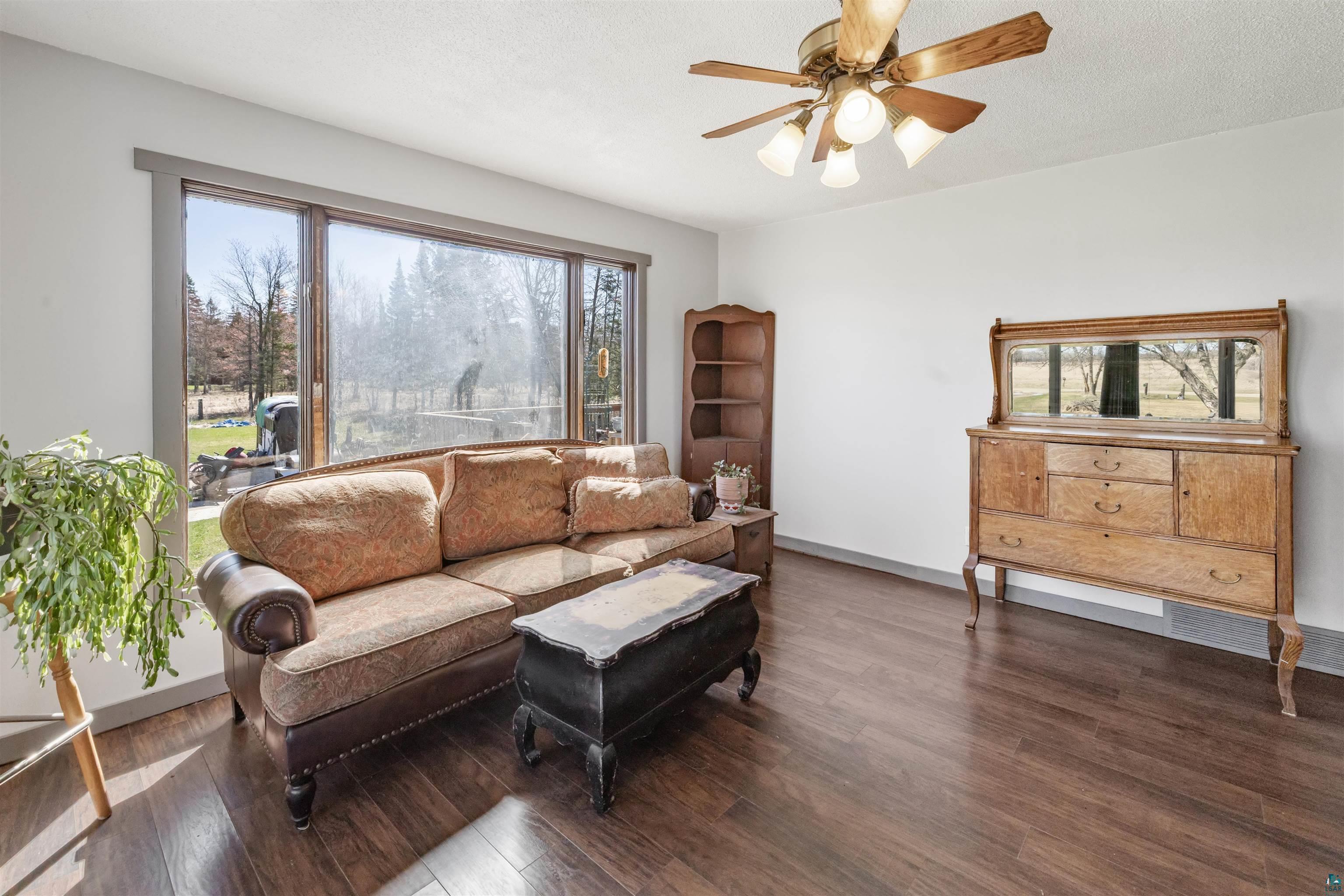 40139 County Road 251 Cohasset, MN 55721 - Photo 2 of 50 Spacious interior featuring large picture windows, laminate flooring, and a ceiling fan with integrated lighting