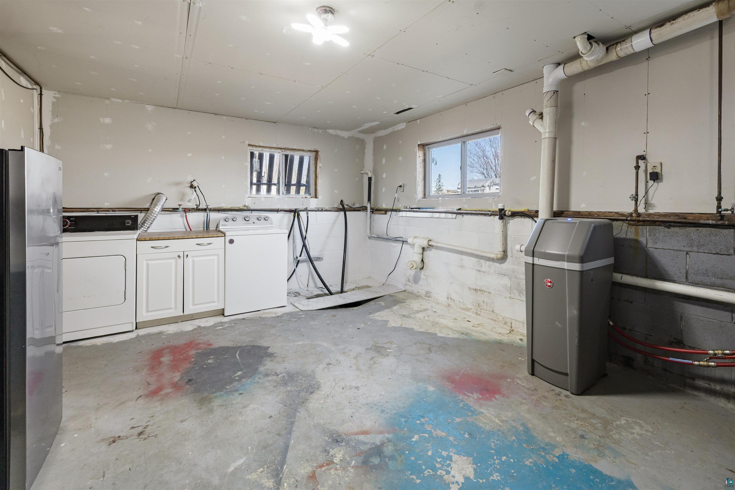 40139 County Road 251 Cohasset, MN 55721 - Photo 26 of 50 Laundry room featuring a washer and dryer, base cabinetry with a wood-finish countertop, and a water softener system