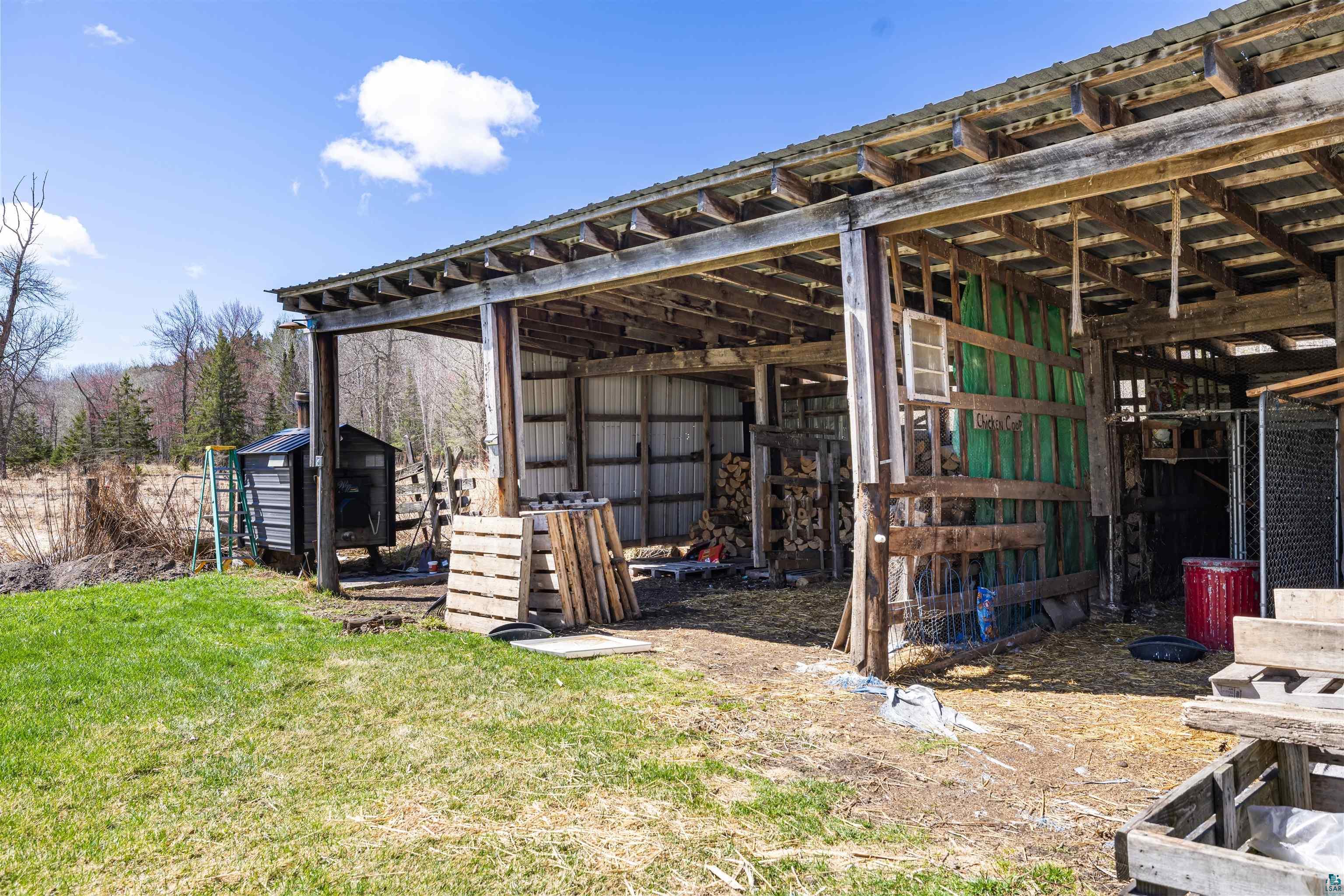 40139 County Road 251 Cohasset, MN 55721 - Photo 32 of 50 Open-sided outbuilding with a metal roof and exposed wood-beam construction