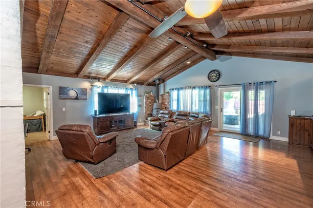 a living room with furniture wooden floor and a flat screen tv