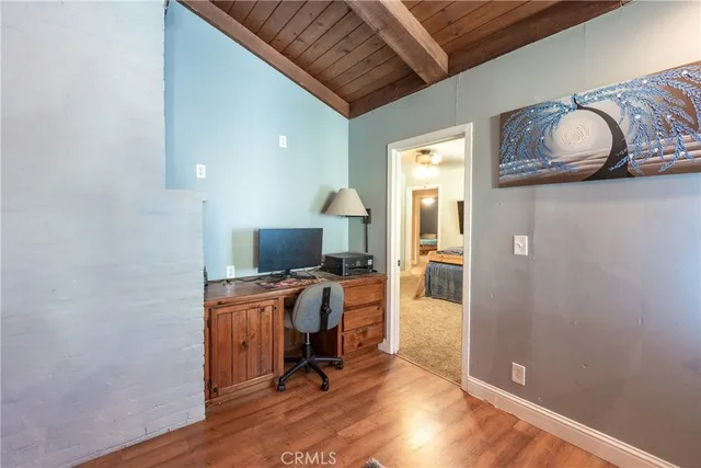 a view of a workspace with furniture and wooden floor
