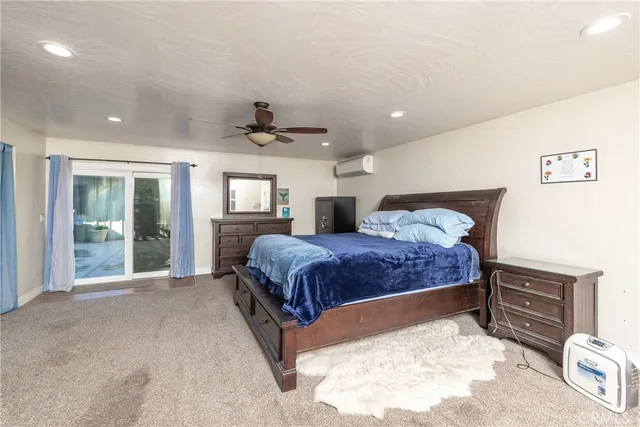 a spacious bedroom with a bed window and dresser