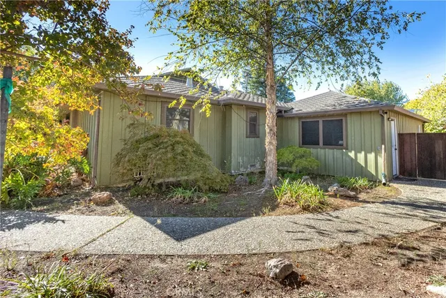 a front view of a house with a yard and potted plants