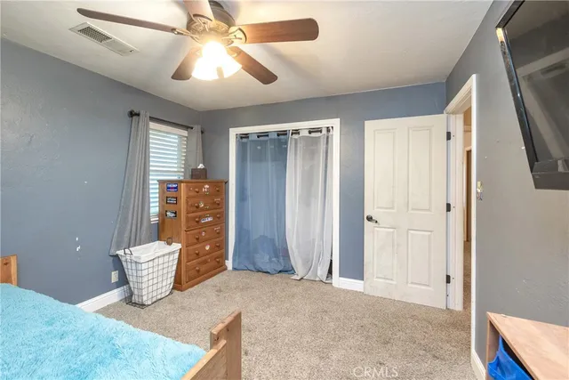 an empty room with windows and fan