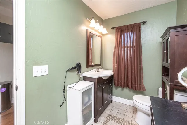 a bathroom with a sink a toilet a mirror and vanity