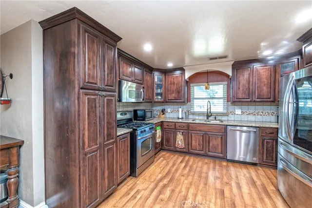 a kitchen with granite countertop stainless steel appliances and wooden cabinets