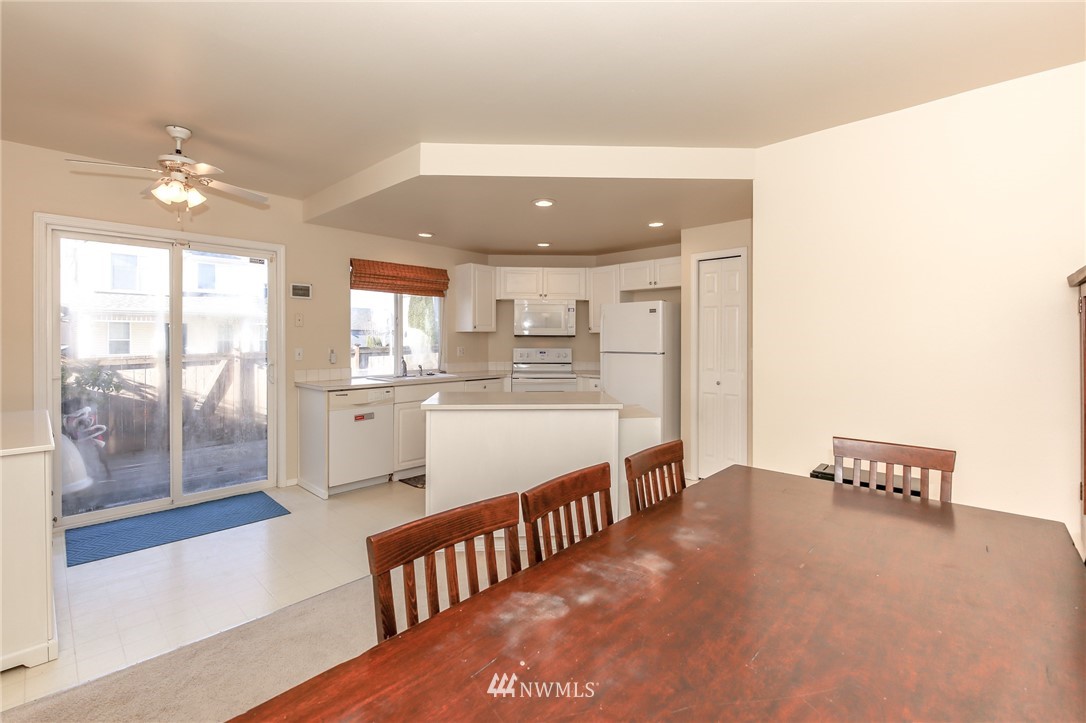 3716 Northeast 5th Place Renton, WA 98056 - Photo 14 of 29 a view of a kitchen with kitchen island stainless steel appliances wooden floor and living room view