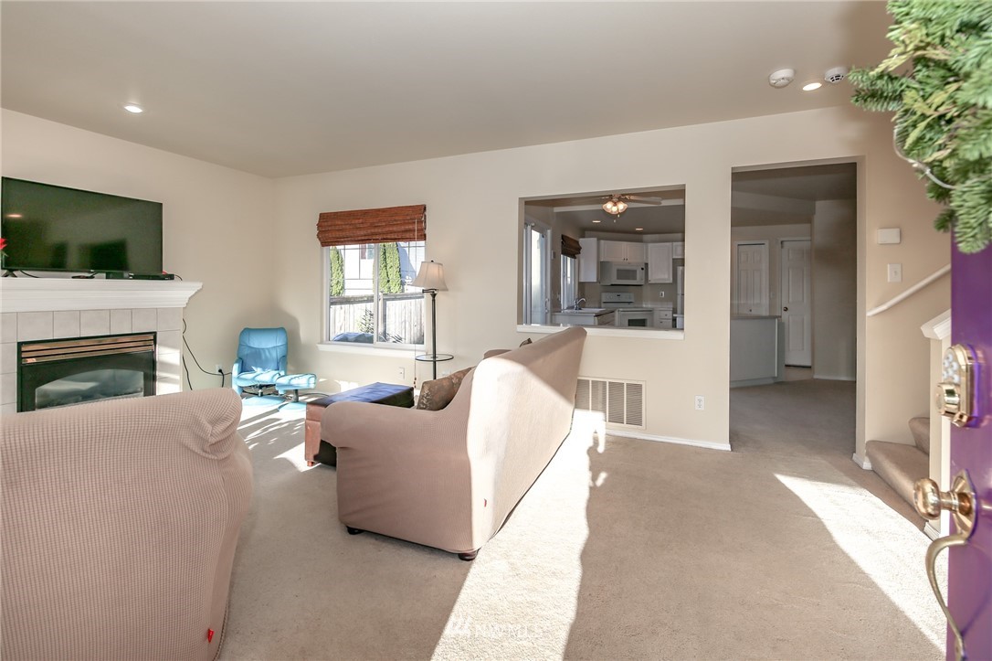 3716 Northeast 5th Place Renton, WA 98056 - Photo 3 of 29 a living room with furniture a flat screen tv and a fireplace