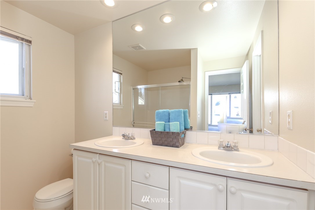 3716 Northeast 5th Place Renton, WA 98056 - Photo 21 of 29 a bathroom with a double vanity sink toilet and a mirror