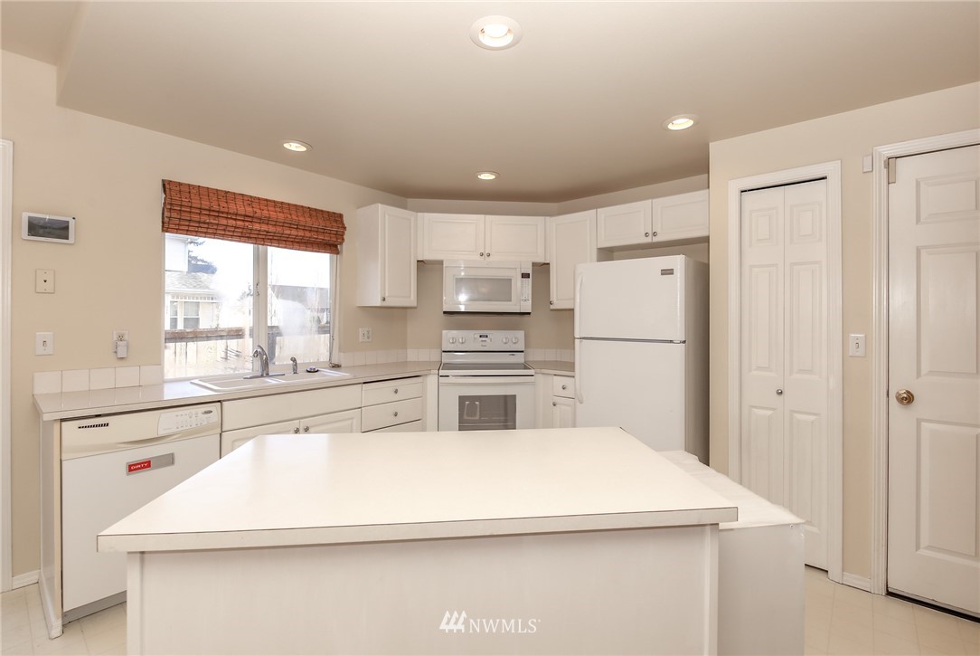 3716 Northeast 5th Place Renton, WA 98056 - Photo 8 of 29 a kitchen with kitchen island white cabinets and refrigerator