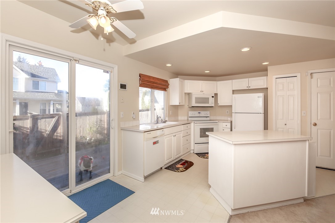 3716 Northeast 5th Place Renton, WA 98056 - Photo 9 of 29 a kitchen with a refrigerator and white cabinets