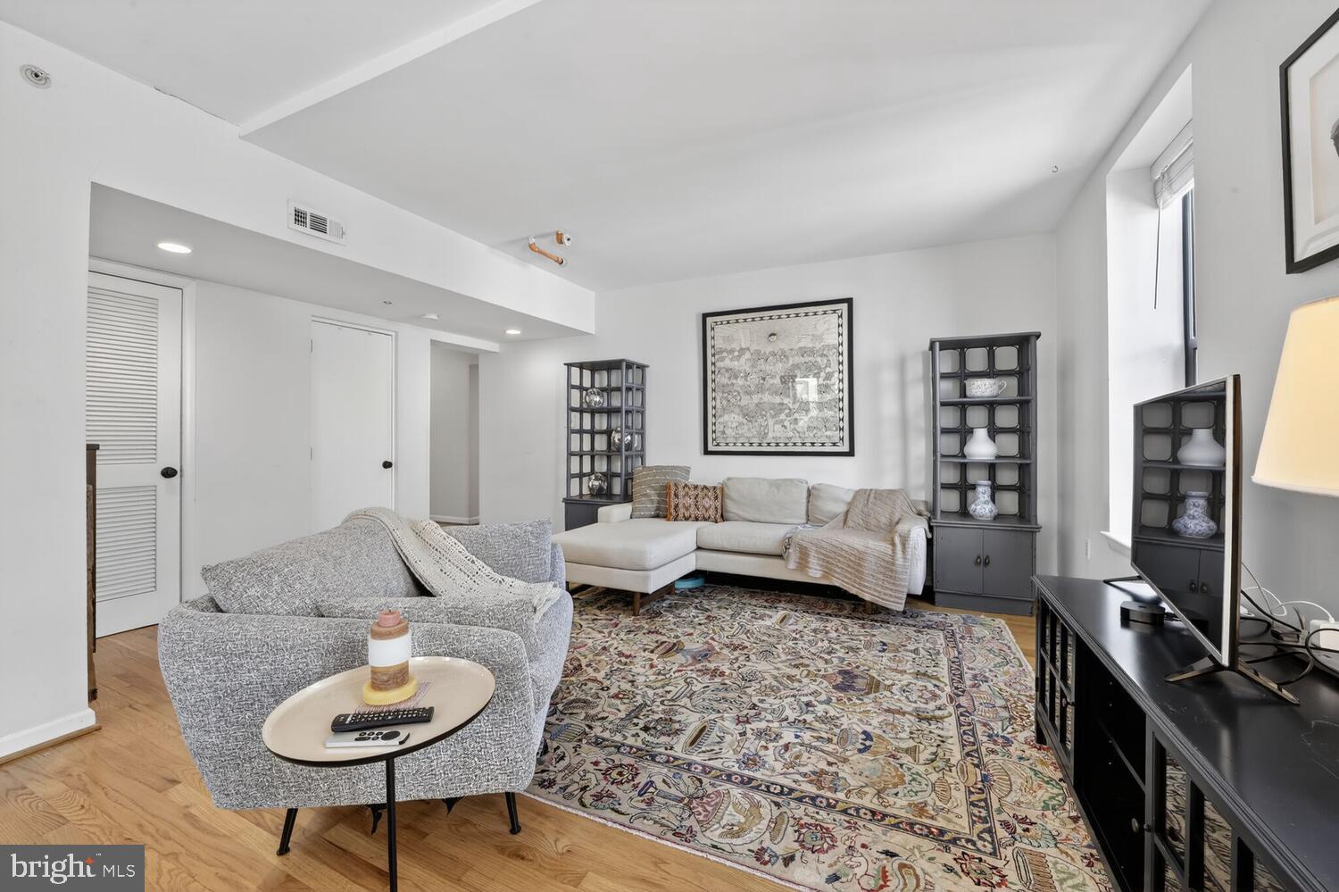 2633 Adams Mill Road Northwest, Unit 205 Washington, DC 20009 - Photo 2 of 18 a living room with furniture and a flat screen tv