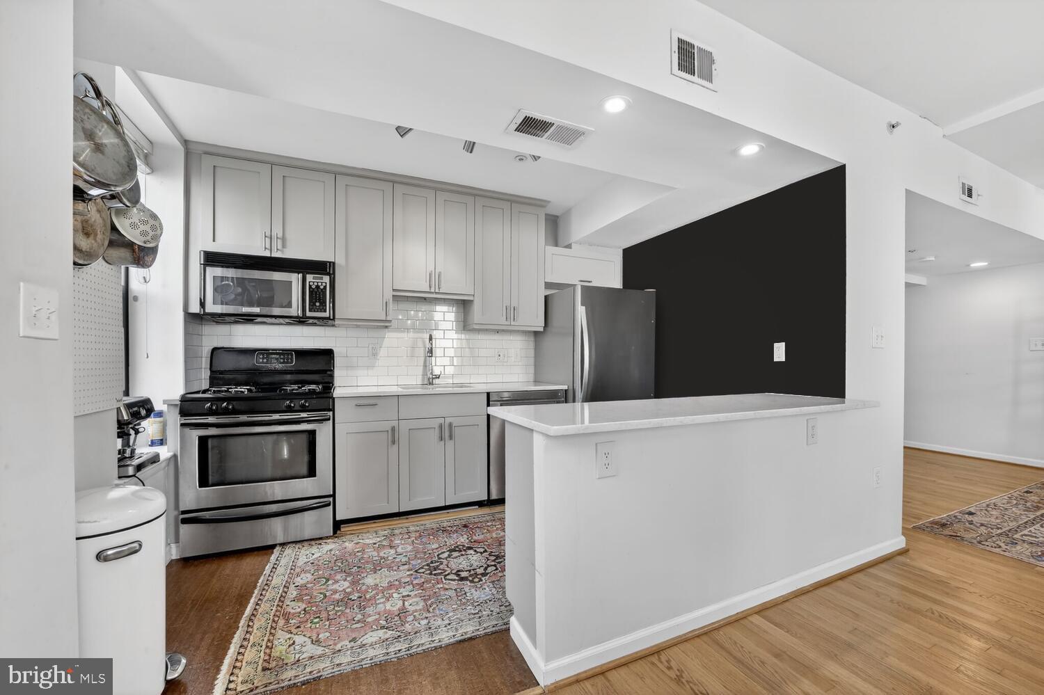 2633 Adams Mill Road Northwest, Unit 205 Washington, DC 20009 - Photo 4 of 18 a kitchen with granite countertop a refrigerator and a stove top oven