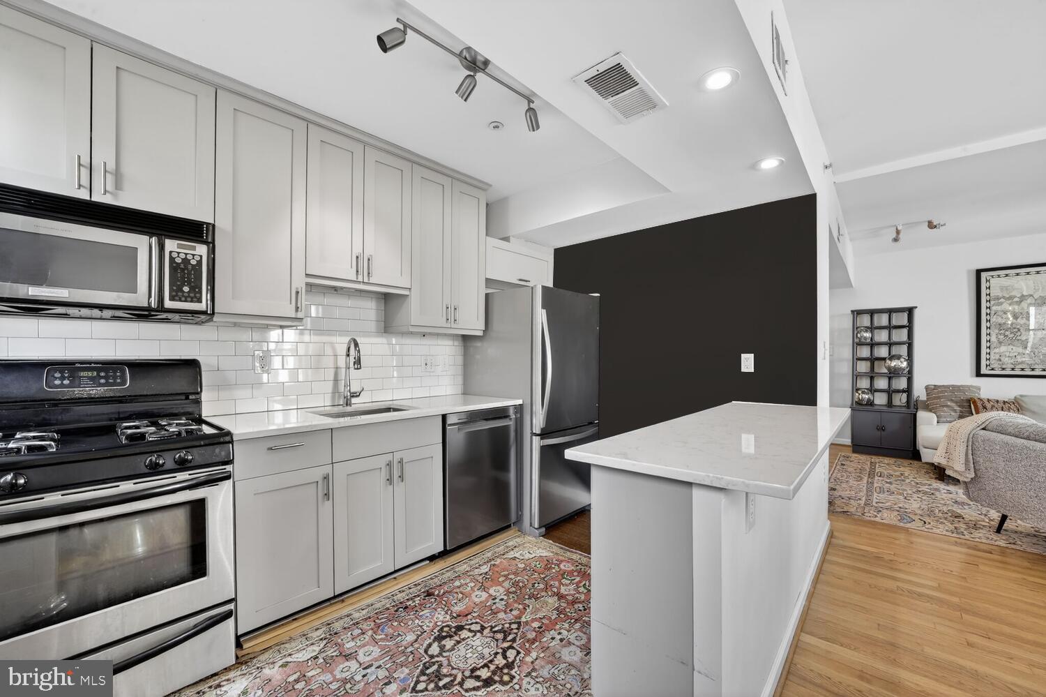 2633 Adams Mill Road Northwest, Unit 205 Washington, DC 20009 - Photo 5 of 18 a kitchen with stainless steel appliances a stove a sink and a refrigerator