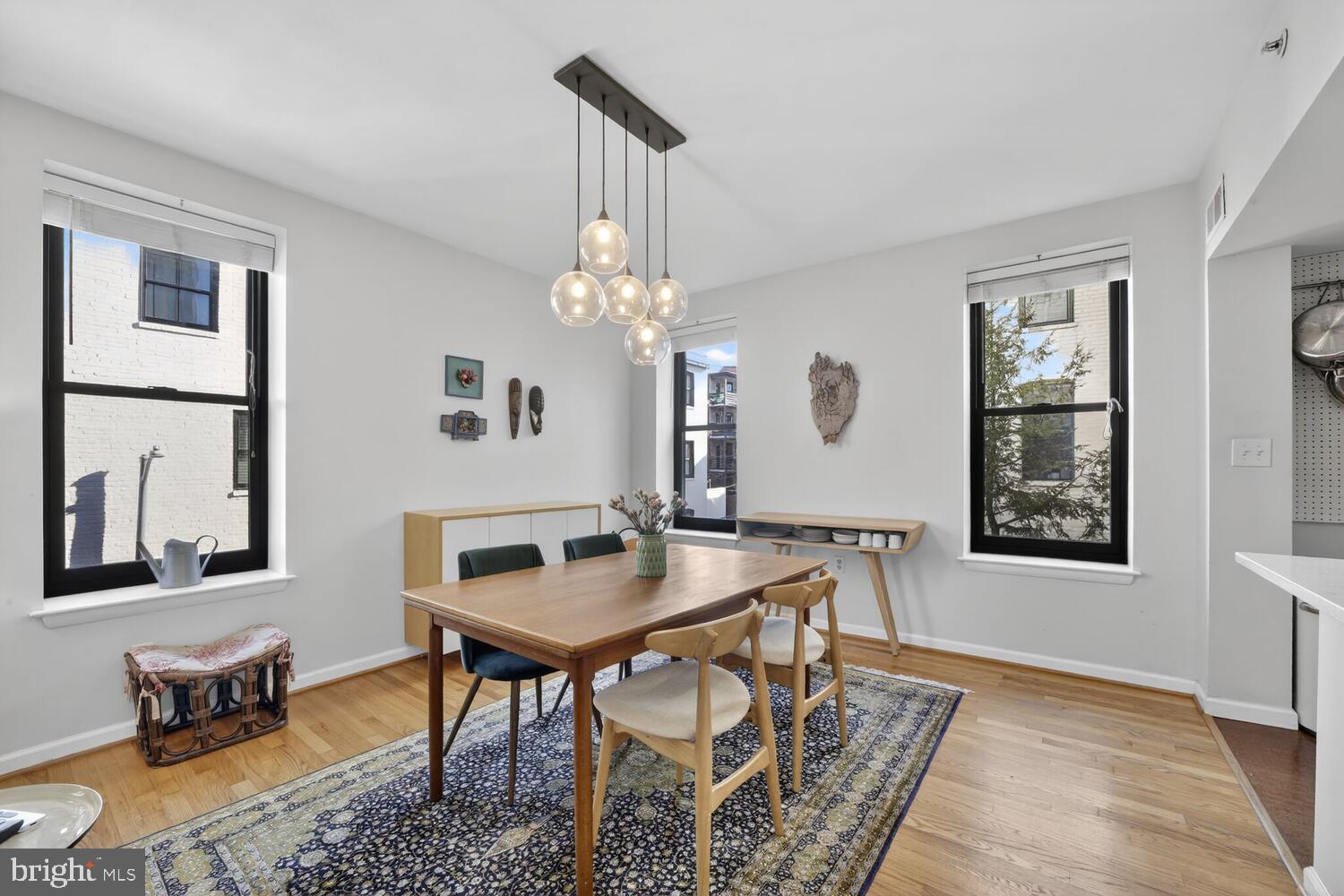 2633 Adams Mill Road Northwest, Unit 205 Washington, DC 20009 - Photo 9 of 18 a dining room with wooden floor a chandelier a wooden table and chairs