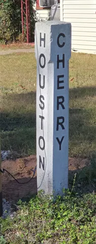 a sign board with a house and yard in the back