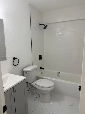 a white toilet sitting next to a bath tub