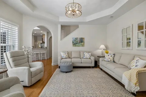 a living room with furniture a chandelier and a flat screen tv