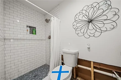 a bathroom with a toilet and a shower curtain
