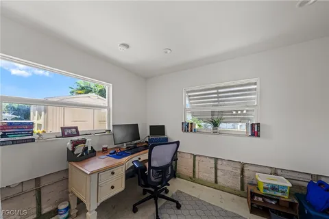 a view of a workspace with furniture and a window