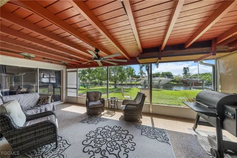 a living room with patio furniture and a garden