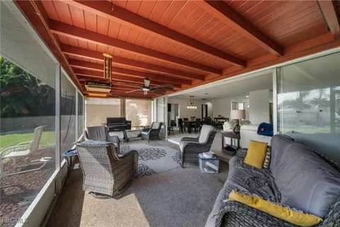 a view of a couch and chairs in patio with a barbeque grill