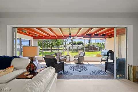 a living room with furniture a rug and a large window