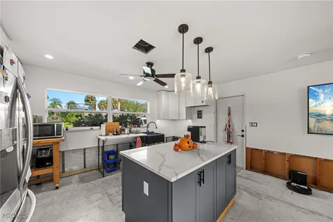 a kitchen with stainless steel appliances a stove a sink a oven a dining table and chairs