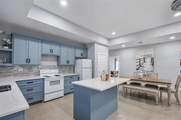 a kitchen with kitchen island a sink stainless steel appliances and cabinets