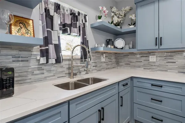 a kitchen with a sink and a stove with wooden floor