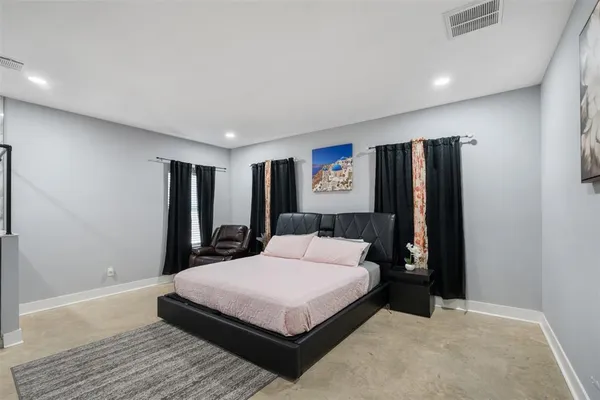 a bedroom with a large bed and a large mirror