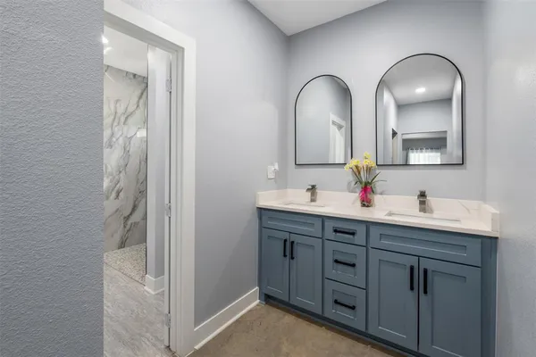 a bathroom with a double vanity sink and a mirror