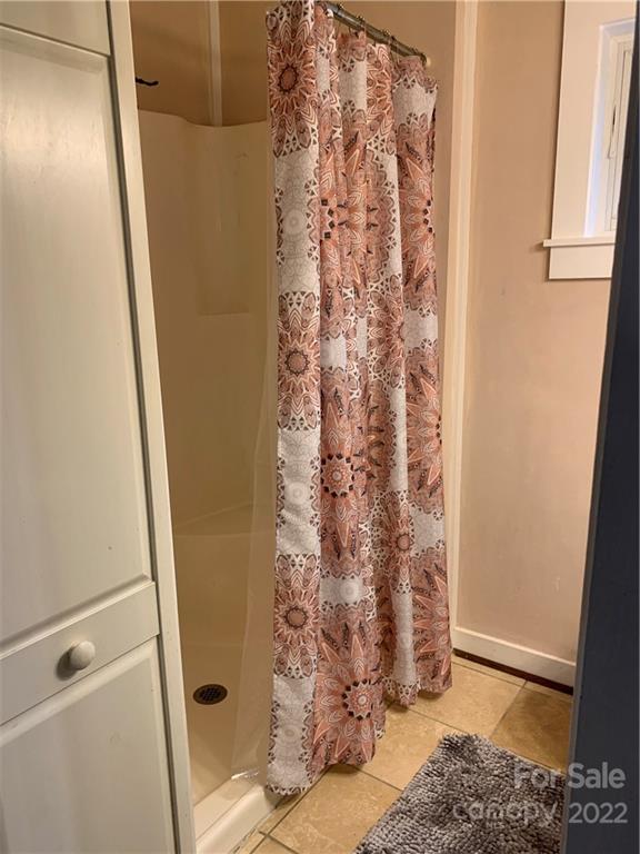 445 Autumn Lane Tryon, NC 28782 - Photo 18 of 27 a bathroom with a shower curtain and a window