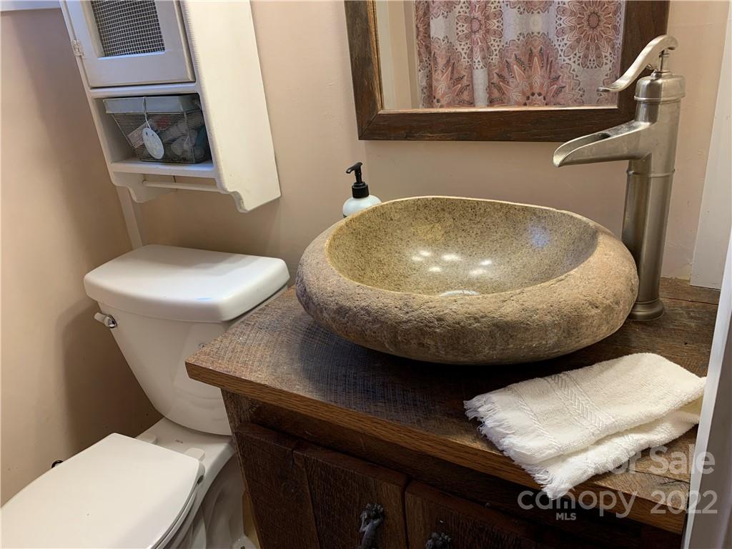 445 Autumn Lane Tryon, NC 28782 - Photo 20 of 27 a bathroom with a toilet a sink and mirror