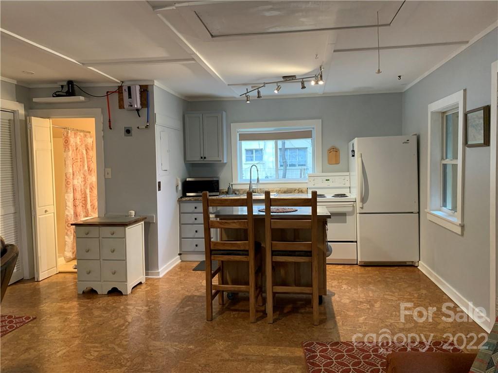 445 Autumn Lane Tryon, NC 28782 - Photo 24 of 27 a kitchen with stainless steel appliances a refrigerator a stove a dining table and chairs with wooden floor