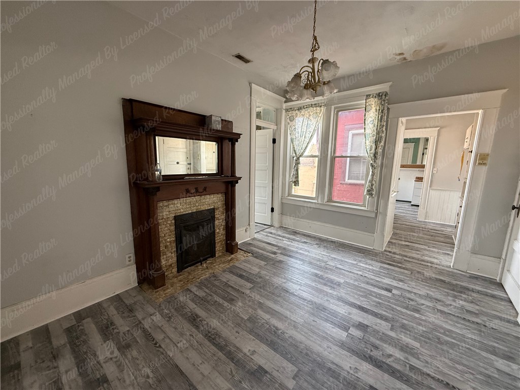 44 West High Street, Unit D Springfield, OH 45502 - Photo 22 of 25 This living space features durable flooring and a charming fireplace, creating a cozy atmosphere.