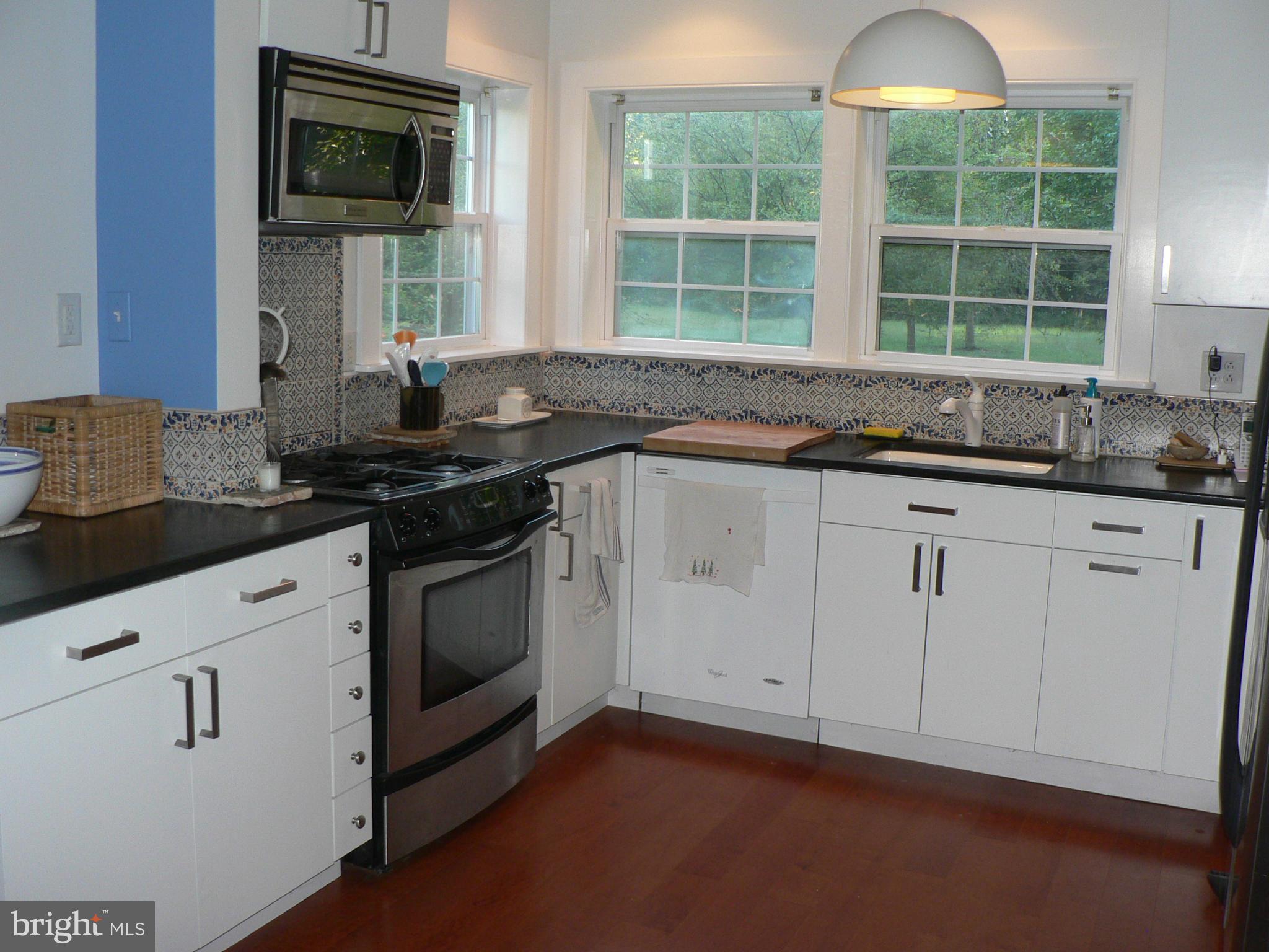 7041 Thorneton Road St. Michaels, MD 21663 - Photo 9 of 19 a kitchen with granite countertop white cabinets and a stove