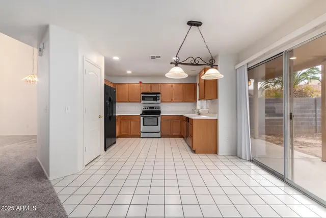 a kitchen with stainless steel appliances granite countertop a refrigerator and a stove top oven